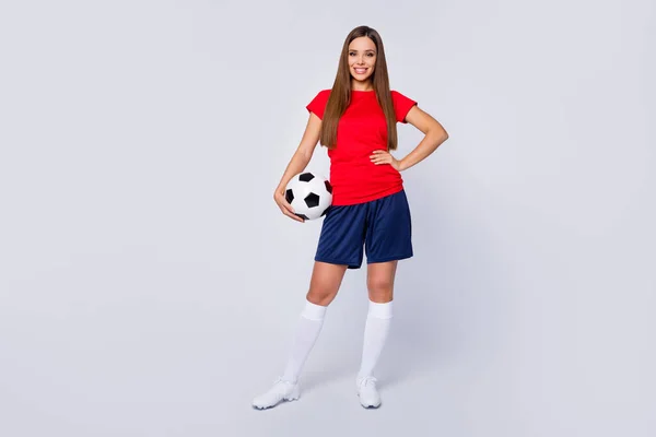 Volledige lengte foto positieve vrolijke voetballer meisje houden voet bal klaar spelen wereld finale kampioenschap voetbal toernooi dragen rood t-shirt blauw shorts schoenen geïsoleerde grijs kleur achtergrond — Stockfoto