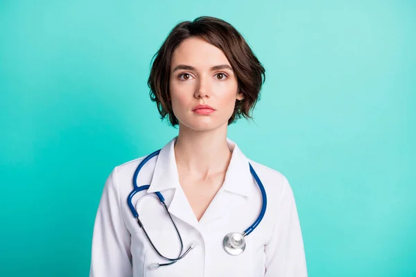 Foto de una mujer joven médico terapeuta seguro serio clínica aislada sobre fondo de color turquesa — Foto de Stock