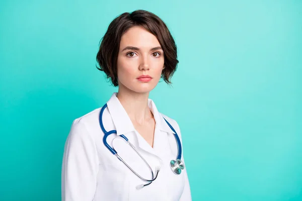 Foto del lado del perfil de una joven mujer seria y confiada pediatra clínica aislada sobre fondo de color turquesa — Foto de Stock