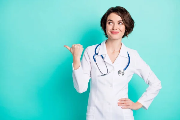 Φωτογραφία της νεαρής γυναίκας γιατρός ευτυχής χαμόγελο δείχνουν αντίχειρα κενό χώρο διαφήμιση promo συστήσει απομονώνονται πάνω teal φόντο χρώμα — Φωτογραφία Αρχείου