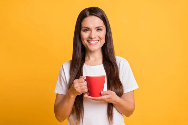 Fotografie de veselă atractivă doamnă matură ține cana roșie de cafea relaxați-vă buna dispoziție izolată pe fundal de culoare galbenă — Fotografie, imagine de stoc