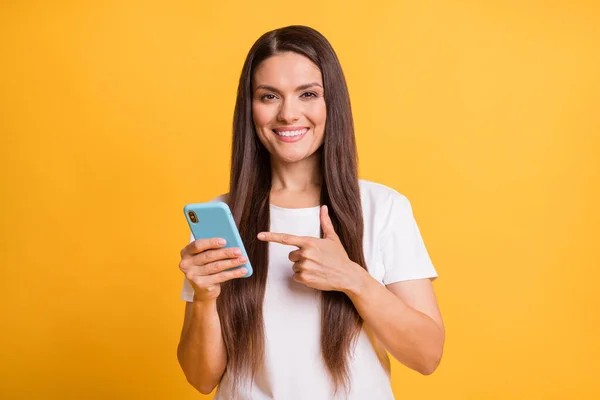 Foto portret van vrouw wijzend met vinger naar mobiele telefoon adviseren adviseren geïsoleerd op levendige gele kleur achtergrond — Stockfoto