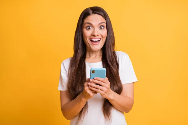Retrato fotográfico de una blogger comentando navegar por internet sonriendo feliz aislada sobre un vibrante fondo de color amarillo — Foto de Stock