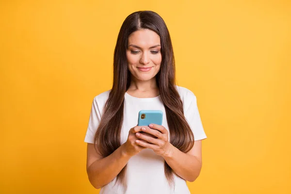 Retrato fotográfico del bloguero escribiendo un mensaje en el teléfono celular sonriendo con ropa casual aislada sobre un fondo de color amarillo vivo — Foto de Stock