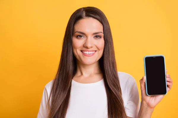 Foto porträtt av vacker kvinna som visar mobiltelefon pekskärm med copyspace leende isolerad på levande gul färg bakgrund — Stockfoto