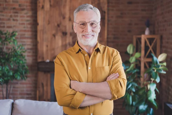 Portrait de l'homme âgé positif mains pliées dents sourire regarder caméra porter lunettes profiter de travailler à partir de la maison à l'intérieur — Photo