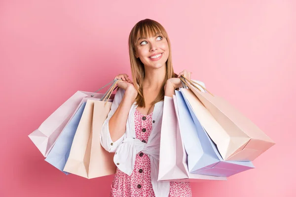 Φωτογραφία πορτρέτο όμορφο κορίτσι ονειρικό αναζητούν κενό χώρο κρατώντας τσάντες μετά τα ψώνια σε καταστήματα που απομονώνονται σε παστέλ ροζ χρώμα φόντο — Φωτογραφία Αρχείου