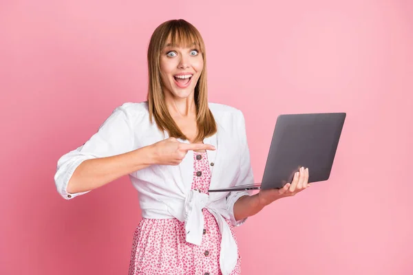 Foto retrato fêmea programador apontando dedo laptop alegre olhando sorrindo isolado no fundo cor-de-rosa pastel — Fotografia de Stock