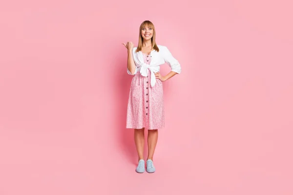 Pleine longueur taille du corps photo de la jeune fille en vêtements décontractés pointant pouce espace vide isolé sur fond rose pastel — Photo