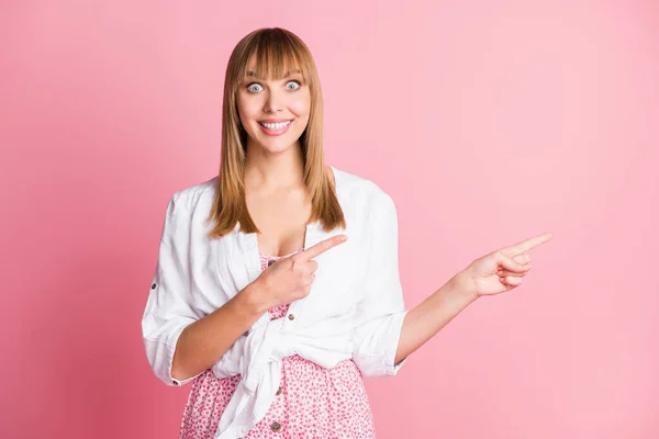 Foto de jovem mulher alegre indicar dedos espaço vazio anúncio promo escolha conselho isolado sobre cor rosa fundo — Fotografia de Stock