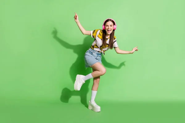 Full size foto van jonge vrolijke positieve stemming vrouw dansen met hoofdtelefoon geïsoleerd op groene kleur achtergrond — Stockfoto