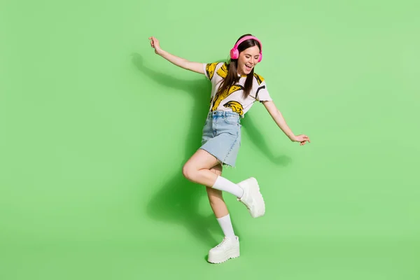 Foto de corpo inteiro de atraente jovem mulher positiva ouvir música dança isolada no fundo de cor verde — Fotografia de Stock