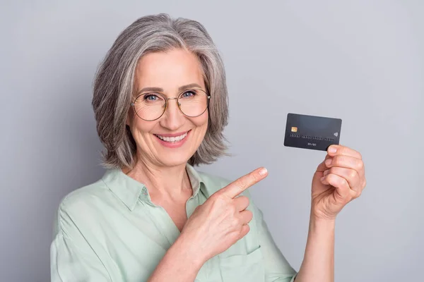 Foto de feliz sorrindo bom humor bela avó recomendando cartão de crédito isolado em fundo de cor cinza — Fotografia de Stock