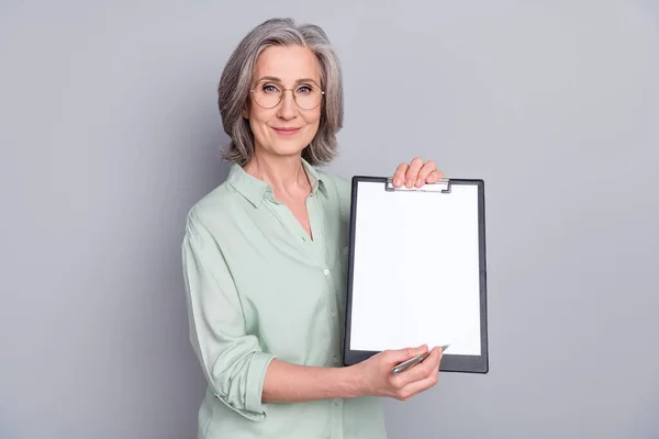 Foto de feliz sonriente positiva hermosa mujer mantenga la firma del documento del punto de lista de verificación aislado en el fondo de color gris —  Fotos de Stock