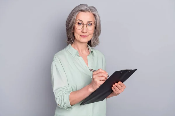 Photo de bonne humeur heureuse belle femme confiante dans des lunettes écriture dans organisateur isolé sur fond de couleur grise — Photo