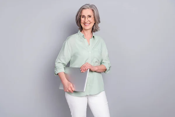Foto van volwassen glimlachen mooie intelligente zakenvrouw houden laptop computer geïsoleerd op grijze kleur achtergrond — Stockfoto