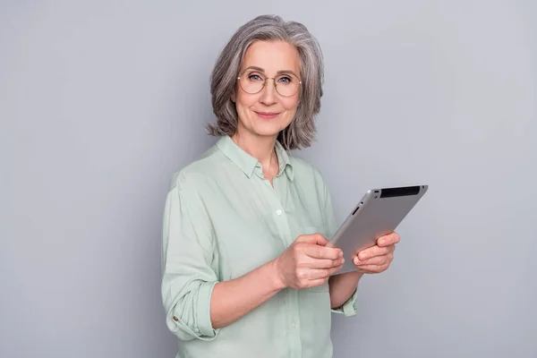 Foto di buon umore felice bella bella donna d'affari in bicchieri tenere tablet isolato su sfondo di colore grigio — Foto Stock