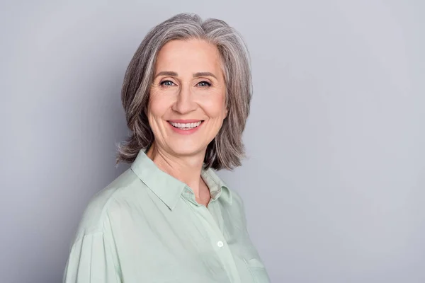 Foto de feliz sorrindo linda linda mulher madura vovó rindo desgaste camisa verde isolado no fundo de cor cinza — Fotografia de Stock