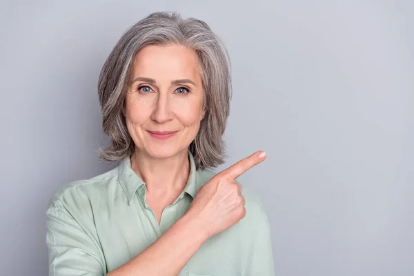 Foto van gelukkig positief goed humeur mooi volwassen vrouw reclame product geïsoleerd op grijze kleur achtergrond — Stockfoto