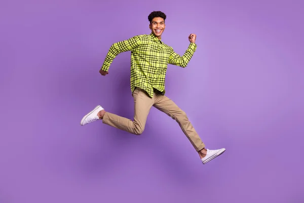 Lunghezza intera dimensione del corpo di giovane salto alta esecuzione veloce sorridente isolato su sfondo di colore viola pastello — Foto Stock