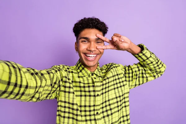 Foto retrato de cara mostrando gesto v-sinal como tirar selfie na camisa xadrez isolado no fundo cor púrpura pastel — Fotografia de Stock