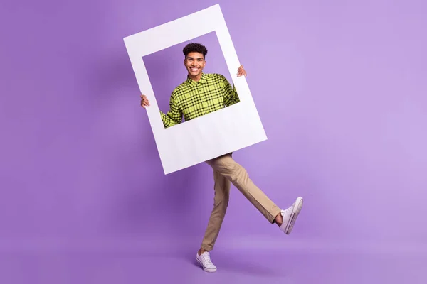 Tamanho total do corpo do jovem mantendo quadro de foto quadro sorrindo na foto isolada no fundo cor violeta pastel — Fotografia de Stock