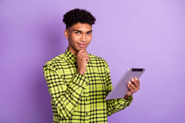 Retrato de chico de mente atractiva usando tableta pensando decidir navegar medios web aislado sobre violeta color púrpura fondo —  Fotos de Stock