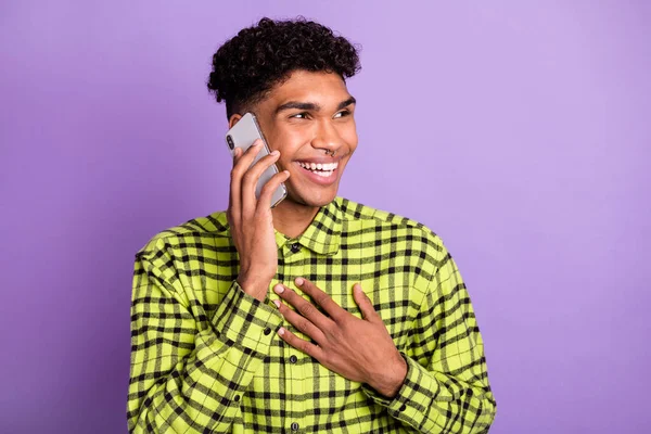 Portrait de beau garçon brunet joyeux parlant au téléphone discuter de bonnes nouvelles isolé sur fond violet couleur pourpre — Photo