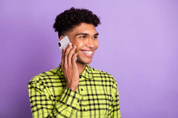 Portrait of handsome cheerful brunet guy talking on cell operator isolated over violet purple color background — Stock Photo, Image