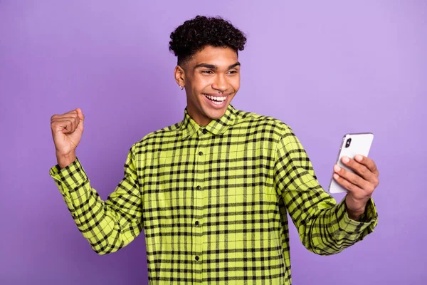 Retrato de chico afortunado alegre atractivo usando gadget celebrando divertirse aislado sobre violeta color púrpura fondo — Foto de Stock