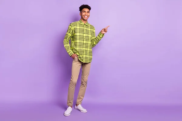 Volledige lichaamsomvang uitzicht van aantrekkelijke vrolijke man demonstreren kopieerruimte advertentie als geïsoleerd over violet paarse kleur achtergrond — Stockfoto