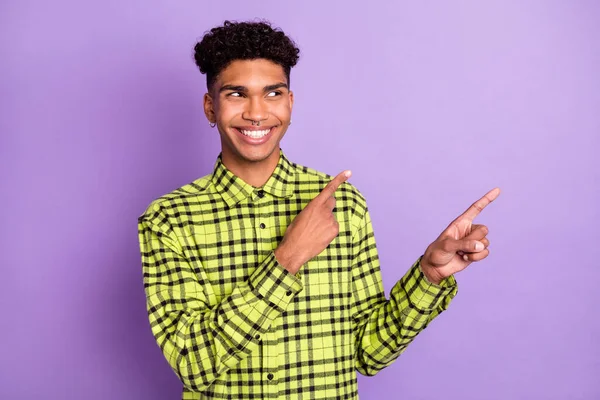 Foto de piel oscura feliz guapo joven punto mirada espacio vacío aislado sobre fondo de color púrpura —  Fotos de Stock