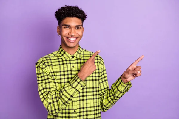 Ritratto di attraente ragazzo allegro indossare camicia a quadri dimostrando spazio copia isolato su viola viola colore sfondo — Foto Stock