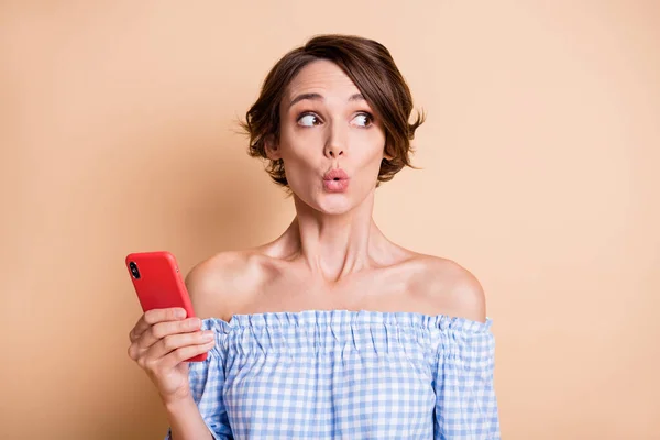 Foto portret van geschokte verbaasd vrouw met telefoon in een hand geïsoleerd op pastel beige gekleurde achtergrond — Stockfoto