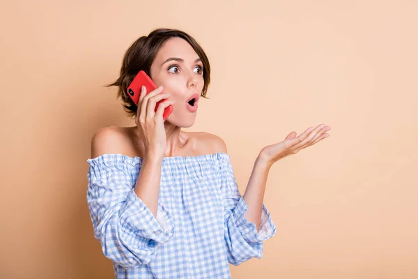 Fénykép portré lenyűgözött nő beszél telefonon elszigetelt pasztell bézs színű háttér — Stock Fotó