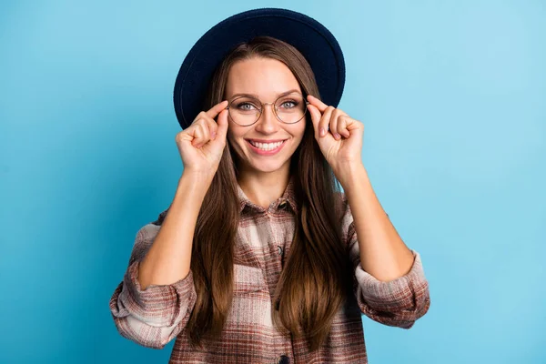 Foto de jovem atraente bonita alegre alegre positivo menina sorrindo usar chapéu e óculos isolados no fundo de cor azul — Fotografia de Stock