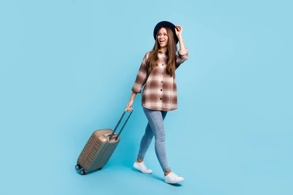 Pełnowymiarowy profil boczny zdjęcie młodej szczęśliwej uśmiechniętej dziewczyny iść na spacer z bagażem izolowane na tle niebieskiego koloru — Zdjęcie stockowe