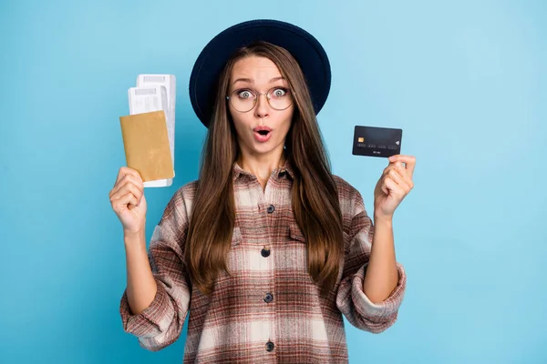 Photo of young happy excied shocked amazed surprised girl hold credit card and tickets isolated on blue color background — Stock Photo, Image