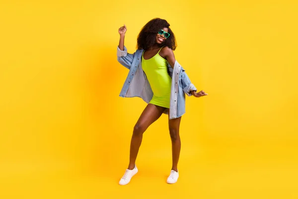 In voller Länge Foto von charmanten funky dunkle Haut Frau tragen Jeans Hemd Brille tanzen isoliert gelbe Farbe Hintergrund — Stockfoto