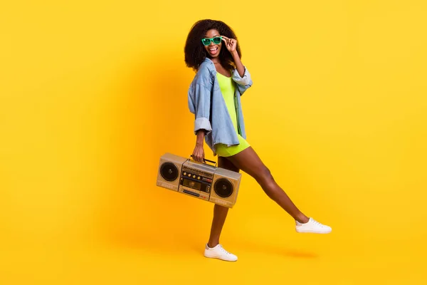 Full length body size άποψη του ελκυστικό χαρούμενο κορίτσι dj deejay μεταφέρουν κασετόφωνο απομονωμένο πάνω από φωτεινό κίτρινο χρώμα φόντο — Φωτογραφία Αρχείου