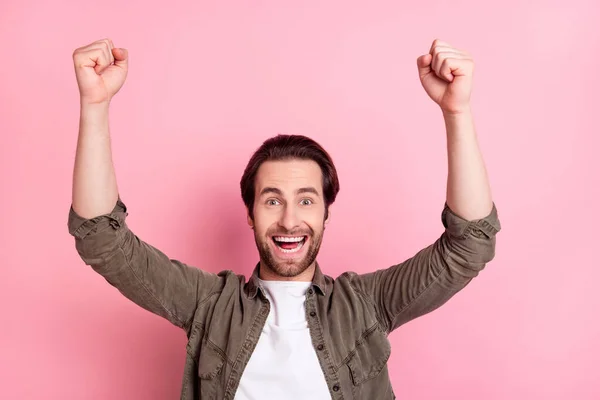 Photo de jeune homme excité heureux sourire positif se réjouir victoire poings mains champion objectif isolé sur fond de couleur rose — Photo