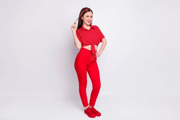 Foto von verspielten flirty girl play curl look Kamera tragen rot gepunktete Bluse Hose Schuhe isoliert graue Farbe Hintergrund — Stockfoto