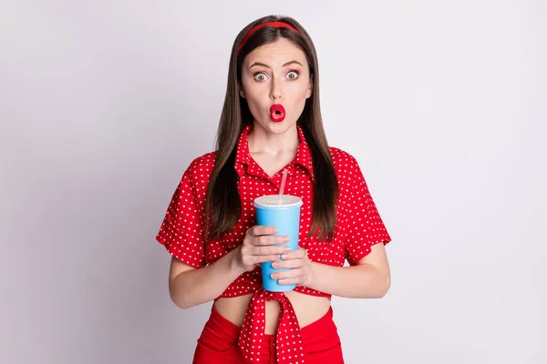 Foto von schockierten verrückten Mädchen halten Plastikbecher aufgeregt aussehen Mund tragen rot gepunktete Bluse isoliert graue Farbe Hintergrund — Stockfoto