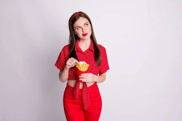 Foto de chica soñadora sostener caja de papel comida rápida mirar espacio vacío usar rojo punteado blusa aislado gris color fondo — Foto de Stock