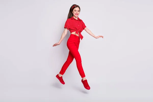 Full längd foto av rolig flicka hoppa steg bära röd prickade blus byxor skor isolerad grå färg bakgrund — Stockfoto