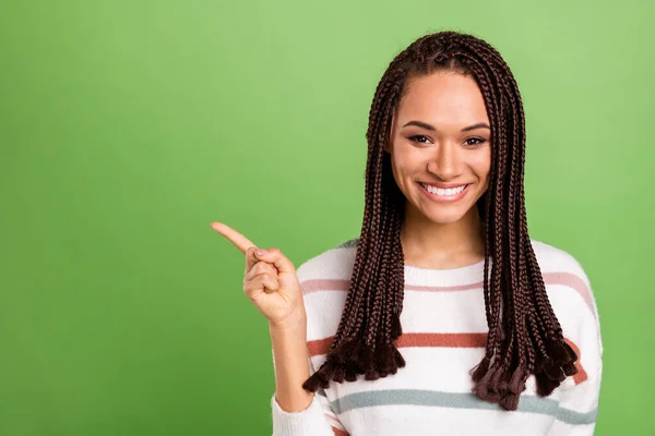 Foto di attraente giovane pelle scura felice donna punta dito vuoto spazio isolato su sfondo di colore verde — Foto Stock