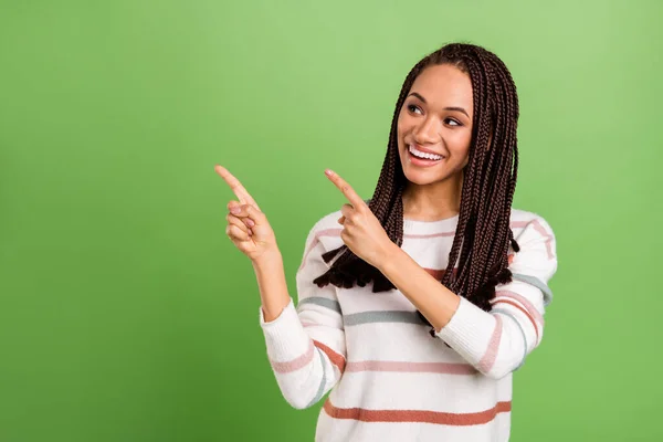 Foto av drömmande unga afro amerikanska kvinna ser pekfingrar tomt utrymme leende isolerad på grön färg bakgrund — Stockfoto