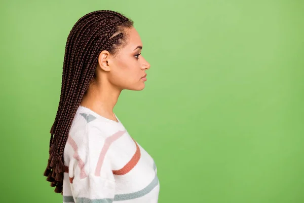 Foto del lado del perfil de la mujer joven de piel oscura mirada espacio vacío cara seria aislado sobre fondo de color verde —  Fotos de Stock