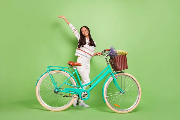 Foto em tamanho completo de jovem afro menina feliz sorriso positivo passeio de bicicleta transporte isolado sobre fundo de cor verde — Fotografia de Stock