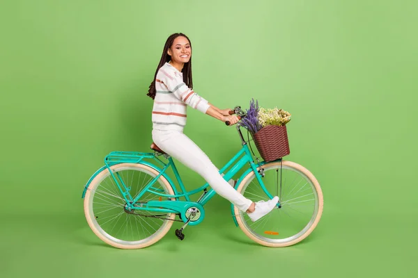 Foto lateral de perfil de tamanho completo da jovem menina preta feliz sorriso positivo passeio de bicicleta de viagem isolado sobre fundo de cor verde — Fotografia de Stock